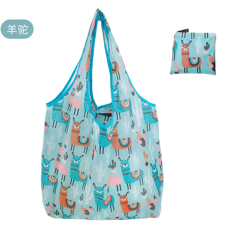 A light blue reusable shopping tote bag featuring a pattern of stylized, colorful desert animals like camels and cacti.