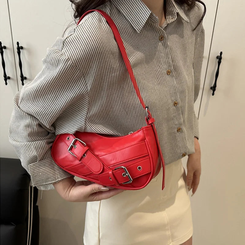 A woman holds a red Y2K vintage PU leather crossbody bag against a striped shirt.