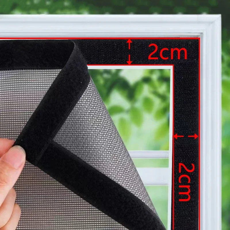 A close-up view of a black mesh window screen being measured with red lines, showing its texture and thickness.