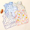 A collection of light-colored baby feeding bibs with various fruit patterns and pastel colors.