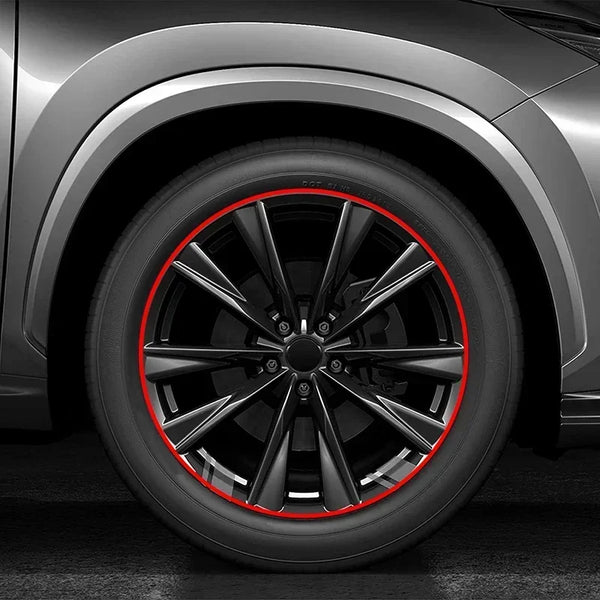 Close-up of a black vehicle wheel with a red protective strip around the rim.