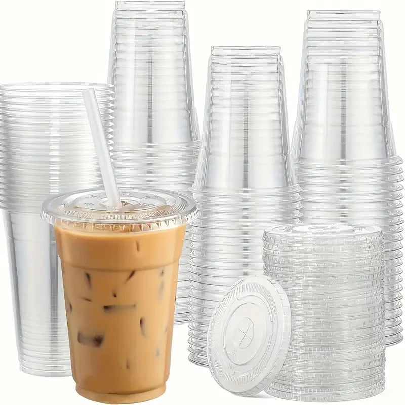 A stack of clear plastic cups with lids and a single cup filled with iced coffee or bubble tea.