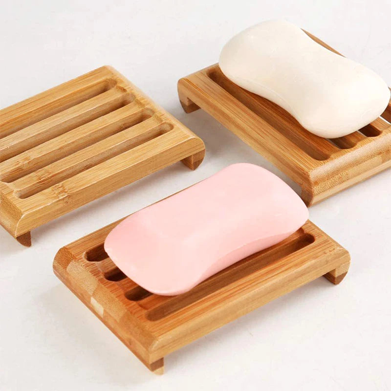Natural bamboo soap dish holding a white bar of soap and a pink bar of soap