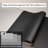 A black premium PU leather desk mat shown in a rolled or folded state on a light surface.