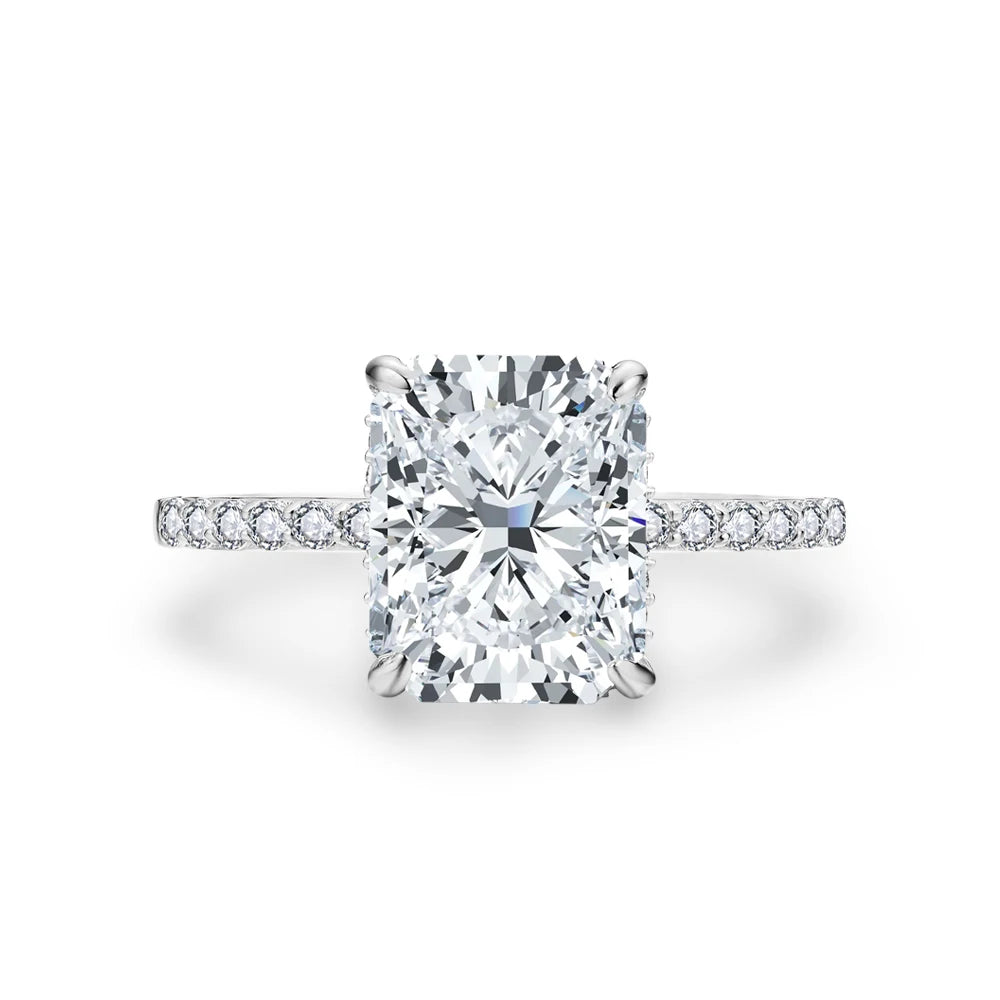A brilliant diamond engagement ring featuring a radiant cut center stone and a hidden halo setting.
