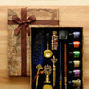 A wooden box containing a three-pen set with various fountain pens and a wax seal stamp kit resting on an old map.