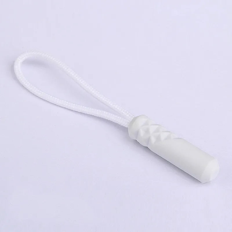 A white replacement zipper pull with a nylon cord attached.