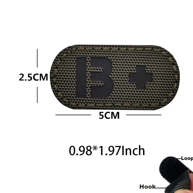 A black glow-in-the-dark blood type patch with a hook and loop backing, measuring 2.5cm by 5cm.