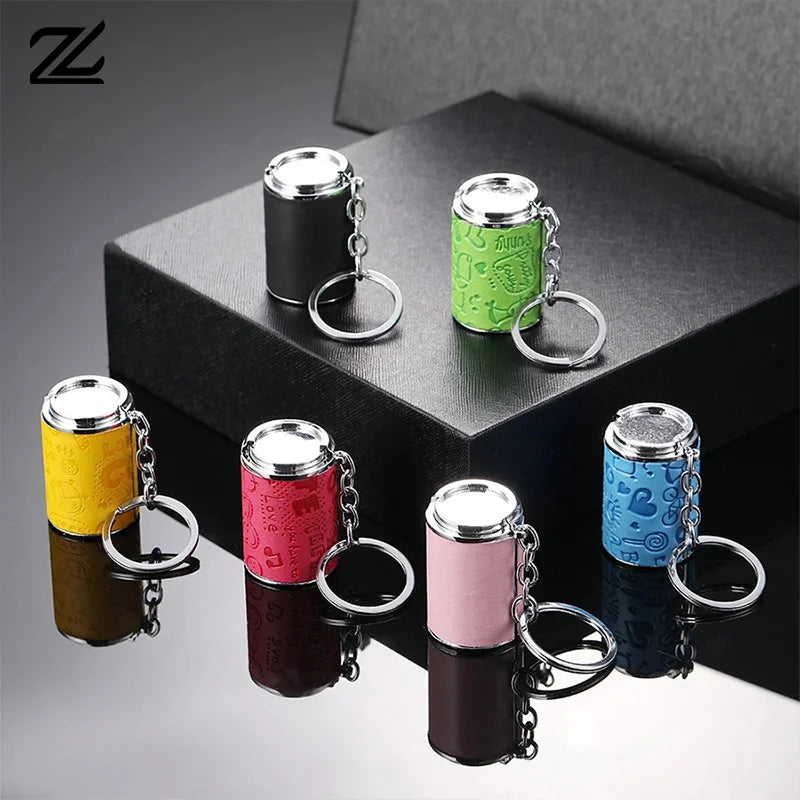 A collection of metal coin tube keychains in various colors, including gold, green, pink, and blue, displayed on a black box.