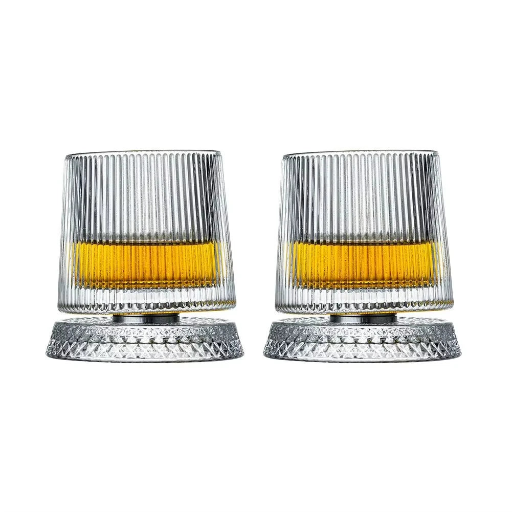 Ein Set aus zwei gerippten Whiskey-Tumblern aus Glas mit bernsteinfarbigem Inhalt.
