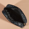 A black compact crossbody bag with a zippered opening and a patterned fabric detail is shown against a beige background.