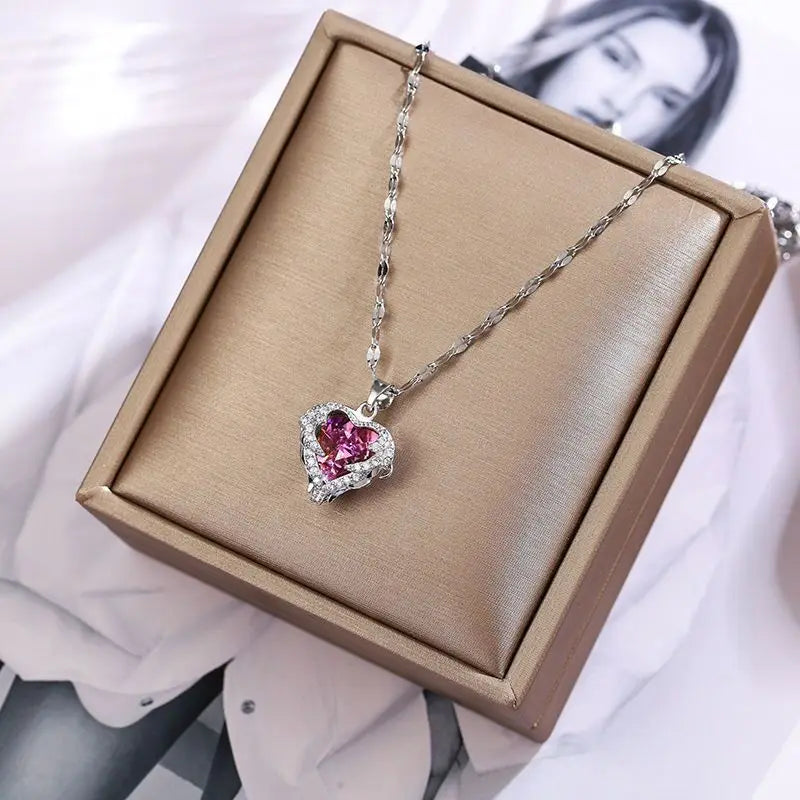 Collier pendentif en argent avec une pierre de cristal rose, présenté dans une boîte marron clair.