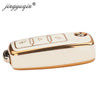 A white TPU silicone car key case with gold accents, featuring multiple buttons for flip keys.