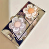 A silver tray holds two glass containers with pink and white floral toilet flush handles.