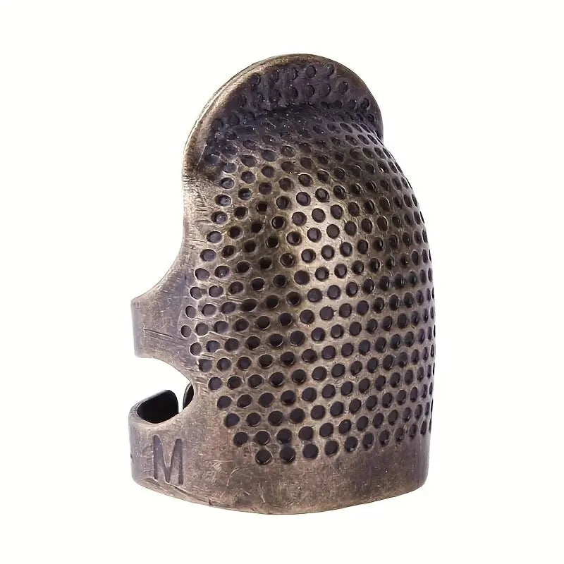 Vintage metal sewing thimble with a finger protector ring, showing the textured surface and 'M' marking.