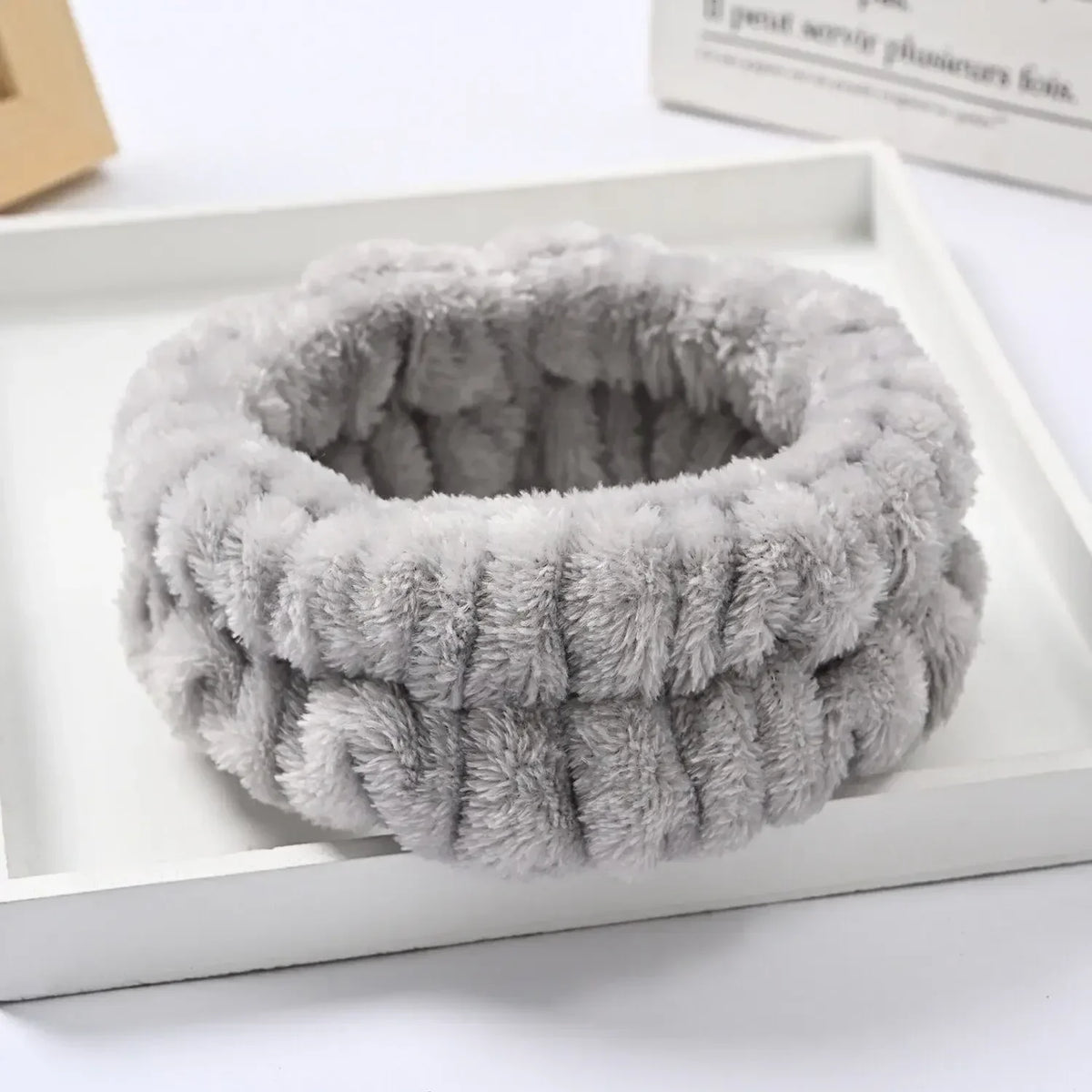 A gray microfiber wrist sweatband and scrunchies for face washing are displayed in a white box.