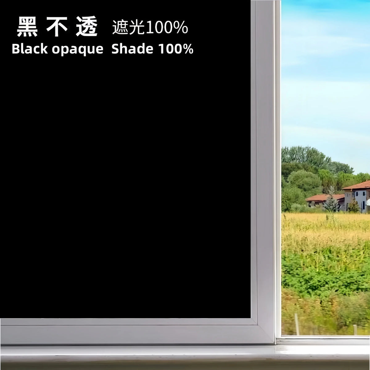 A close-up view of a window with black opaque shade film applied, showing a bright outdoor landscape.
