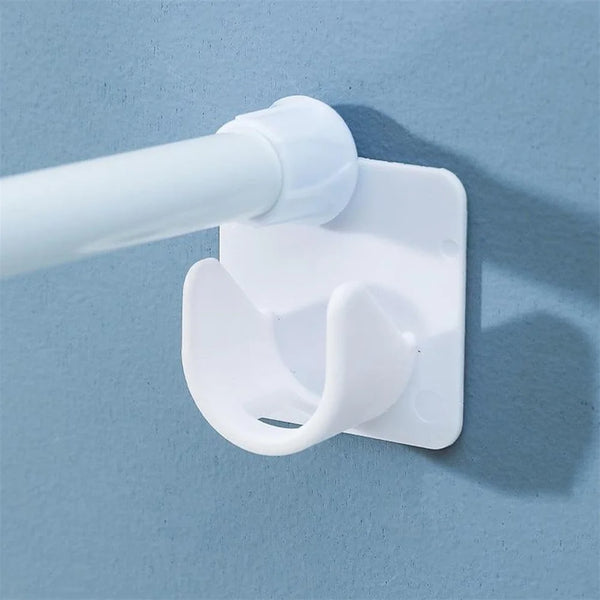 A white self-adhesive curtain hook is attached to a white pole, mounted on a light blue wall.