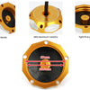 A round, gold-colored aluminum fuel tank cap with a black rubber seal and a central threaded post.