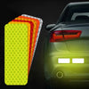 A set of reflective car safety strips in various colors, including yellow and orange, displayed next to a dark car's tailligh