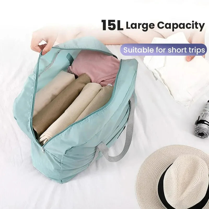 A teal foldable travel duffel bag is shown open, containing rolled-up clothing and next to a straw hat.