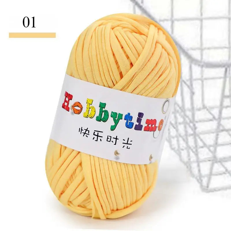 A ball of yellow soft T-shirt yarn for crochet and knitting is shown next to a wire basket.