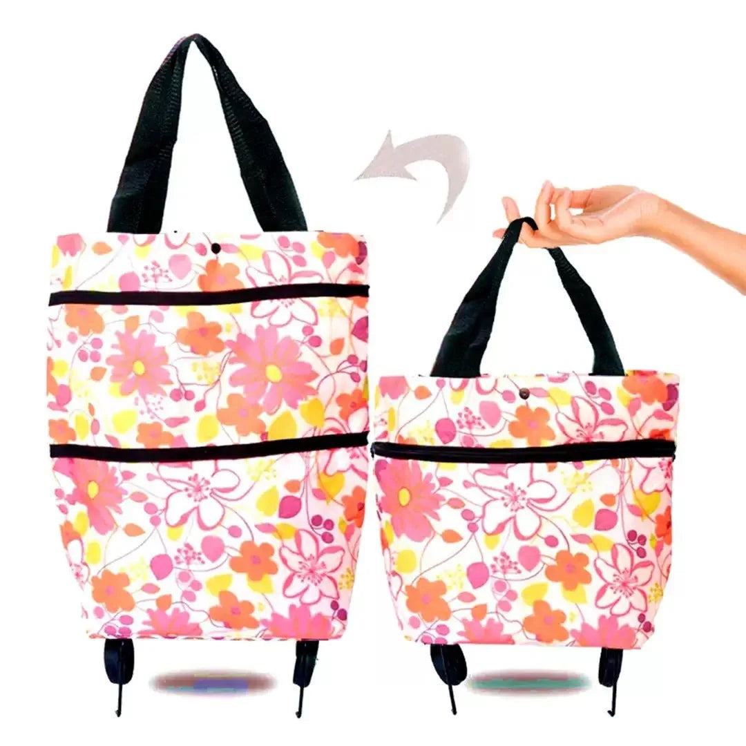 A pink floral patterned foldable rolling shopping bag with black handles and wheels.