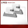 Two white groove cleaning brushes with gray heads resting on a gray cloth.
