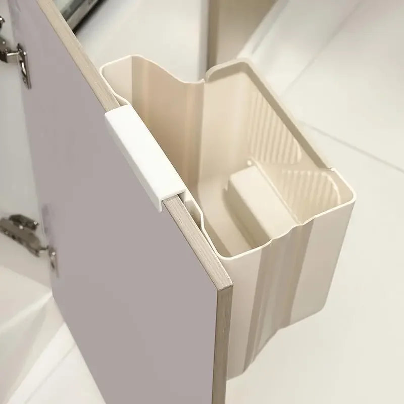 Beige, faltbare Küchen- und Campingmülltonne, geöffnet auf einer Schranktür.