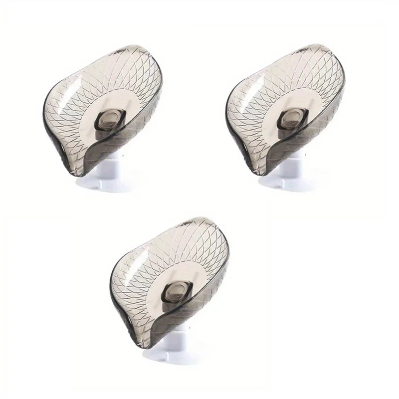Three views of a leaf design self-draining soap dish with suction cup in a translucent gray finish.