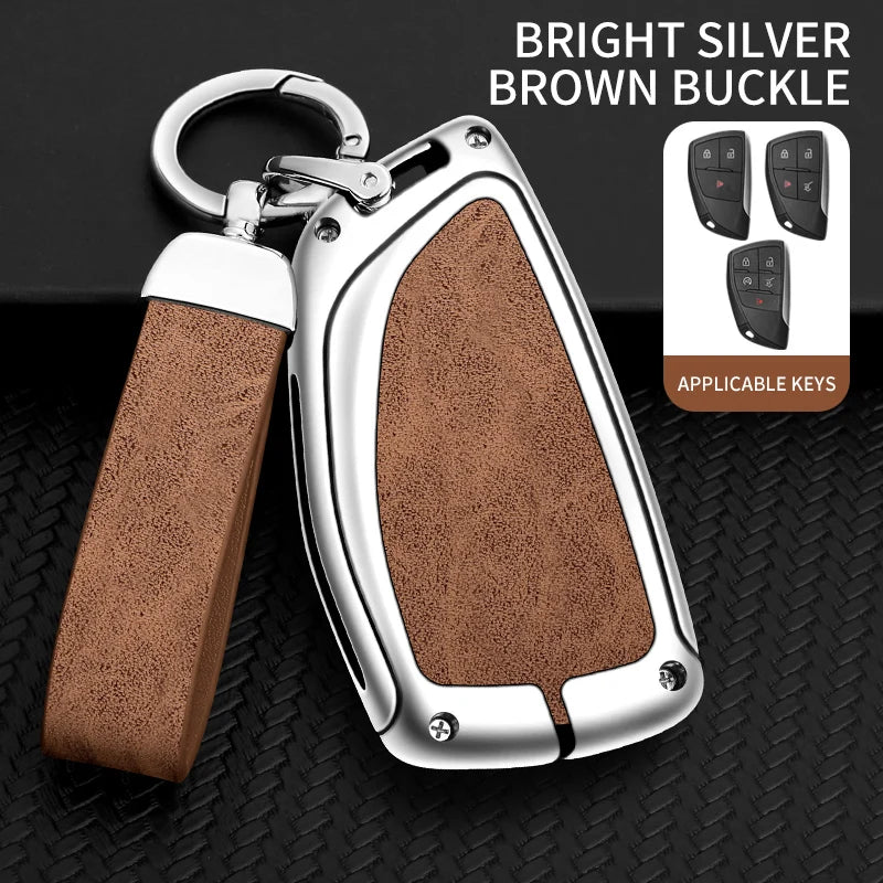 A silver key case with a brown buckle and leather strap is shown against a black background.
