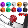 A set of four colored aluminum alloy dice design tire valve caps displayed on a metal surface.