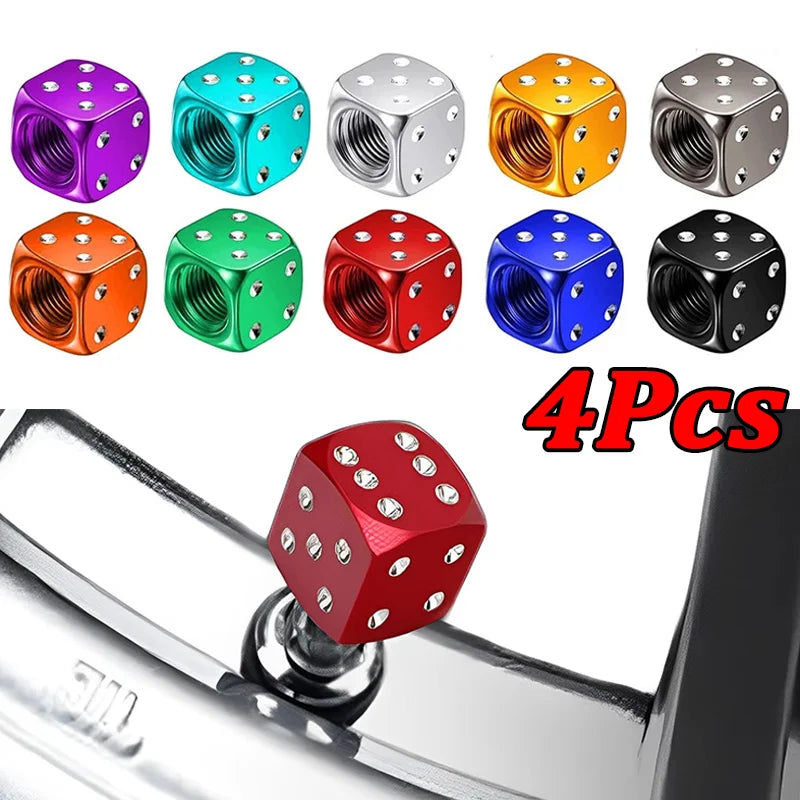 A set of four colored aluminum alloy dice design tire valve caps displayed on a metal surface.