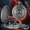 A silver dragon-themed pocket watch case is open, revealing a chain and a large metal die with a dragon design.