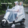 A woman wearing a transparent waterproof motorcycle rain poncho with hood rides a white scooter on a wet road.