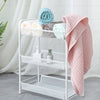 A white wire shelf display featuring rolled, pastel-colored waffle weave bath towels.