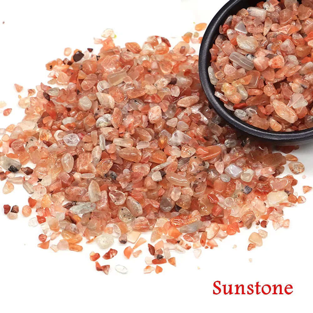 Pile of reddish-orange Sunstone crystal chips and tumbled stones.