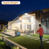 A bright outdoor flood light illuminates a garden area at night, demonstrating the 10-26ft sensing distance.