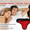 A red light therapy device shaped like a prostate, resting on a white pillow next to a couple.