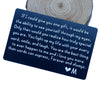 A dark blue card with white text expressing love and appreciation, placed on a wooden surface.