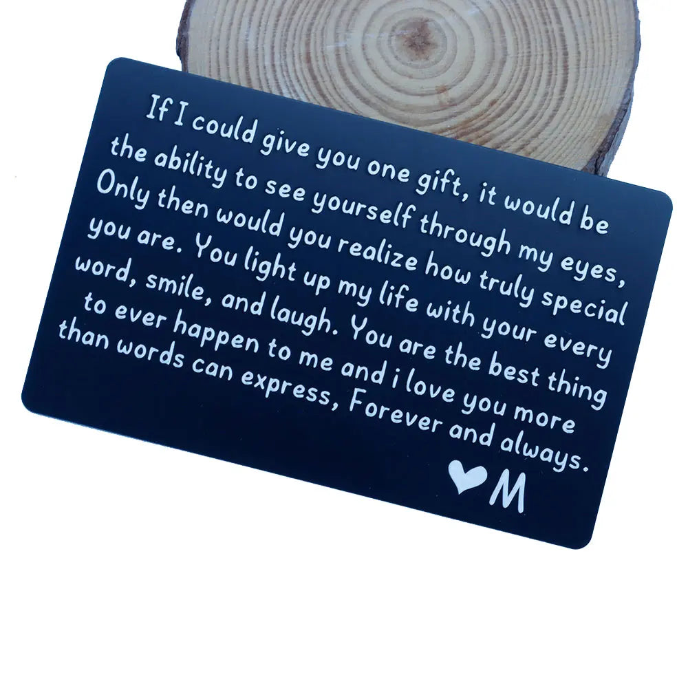 A dark blue card with white text expressing love and appreciation, placed on a wooden surface.