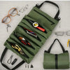 A dark olive green roll-up multi-pocket tool organizer bag filled with various small tools and glasses.