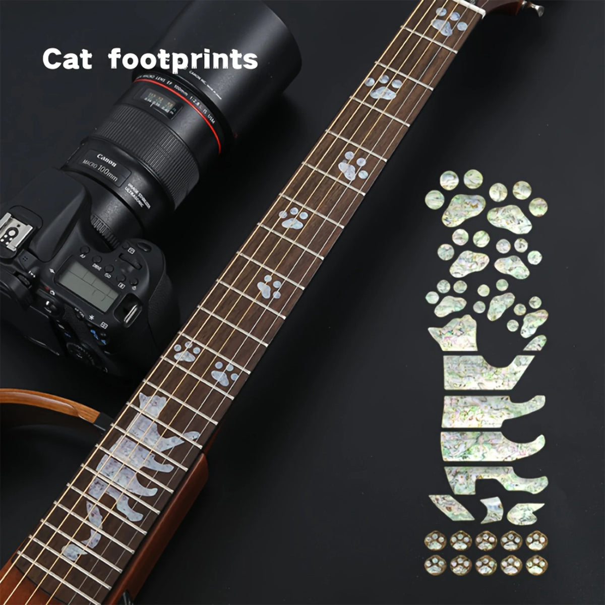 A close-up of a guitar fretboard featuring cat footprints as an inlay sticker decal.