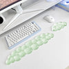 A light green cloud-shaped ergonomic wrist rest set for a keyboard and mouse placed on a white desk.