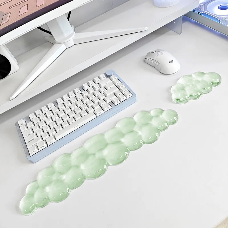 A light green cloud-shaped ergonomic wrist rest set for a keyboard and mouse placed on a white desk.