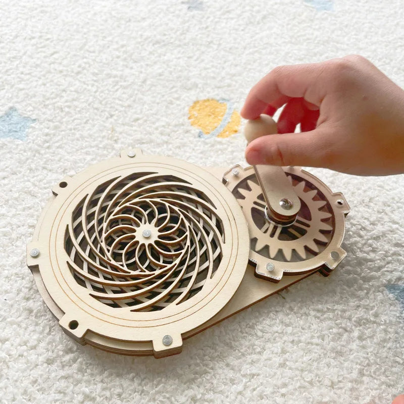A hand is assembling a wooden puzzle featuring gears and a decorative wheel for a toddler learning busy board kit.