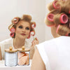A woman is shown using an acrylic bathroom storage set with bamboo lids to style her blonde hair in curls.