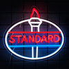 A neon sign shaped like a truck with the word STANDARD glowing in red and blue on a dark background.