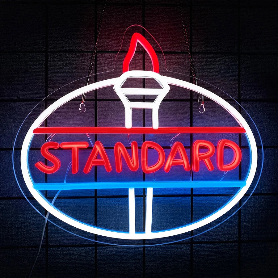 A neon sign shaped like a truck with the word STANDARD glowing in red and blue on a dark background.