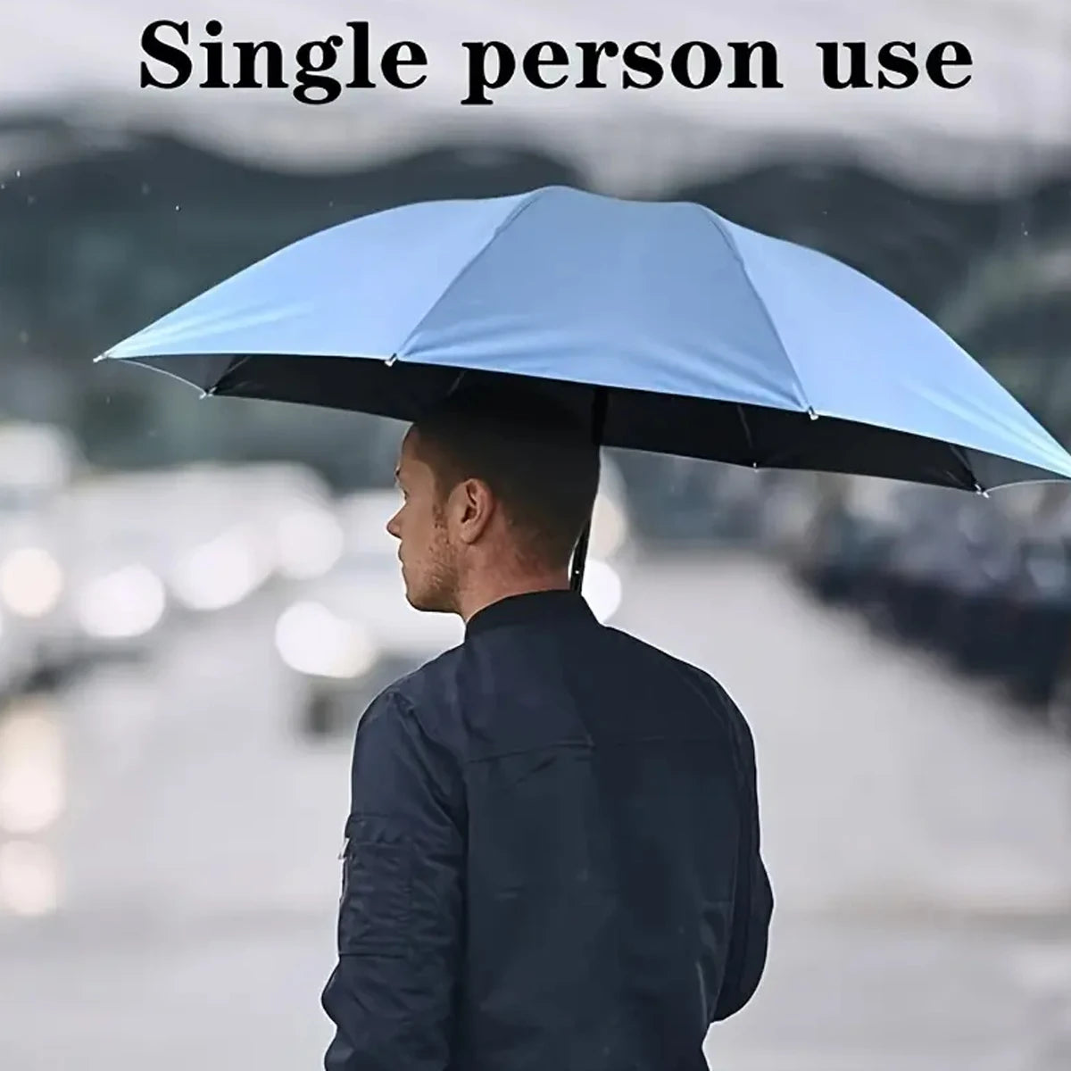 A person holding a light blue umbrella outdoors against a blurred background.